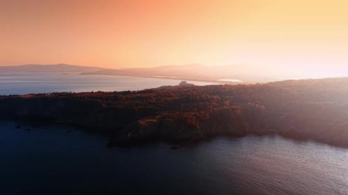 Sonnenuntergang über der Wasserlandschaft und der felsigen Küste. Luftperspektive auf die nautische Landschaft farbig