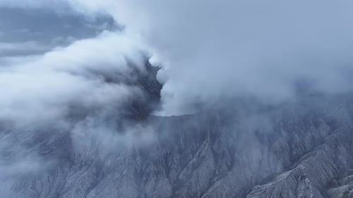aerial view flying to mount Bromo active volcano above sea of clouds, Java, Indonesia