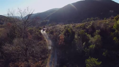 Fast rally car driving off road at sunset areal footage FPV