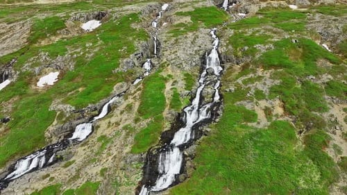 Der Fluss fließt im Sommer durch Berge, Wasserfälle auf Hügeln in Island, Nature Epic Aerial