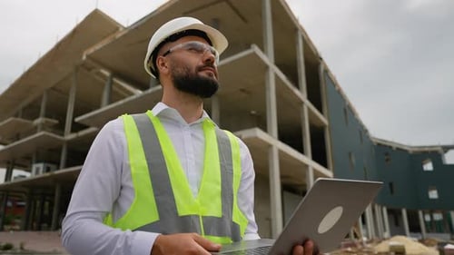 Construction Manager Engineer Using Laptop at Building Site