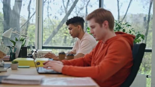 Diverse Young Adults Working Together at Laptop
