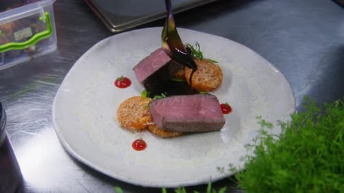 Gourmet Food Preparation: Plated Meat Being Sauced