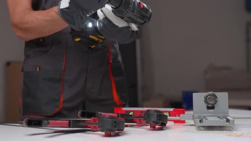Man Using Cordless Drill with Gloves in Workshop