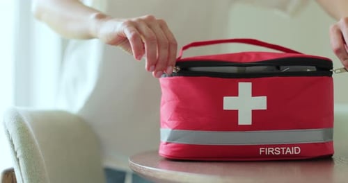 Opening Bright Red First Aid Kit in Home