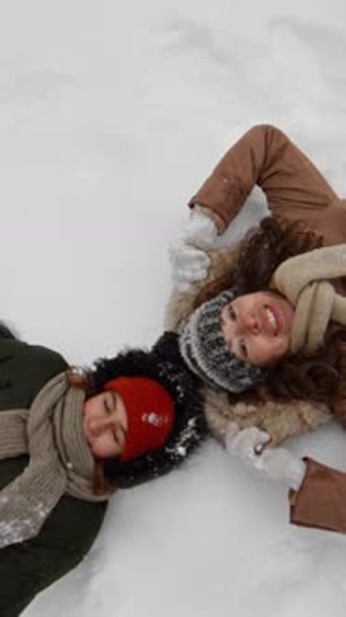 Two Young Women Lying in Snow Making Angels