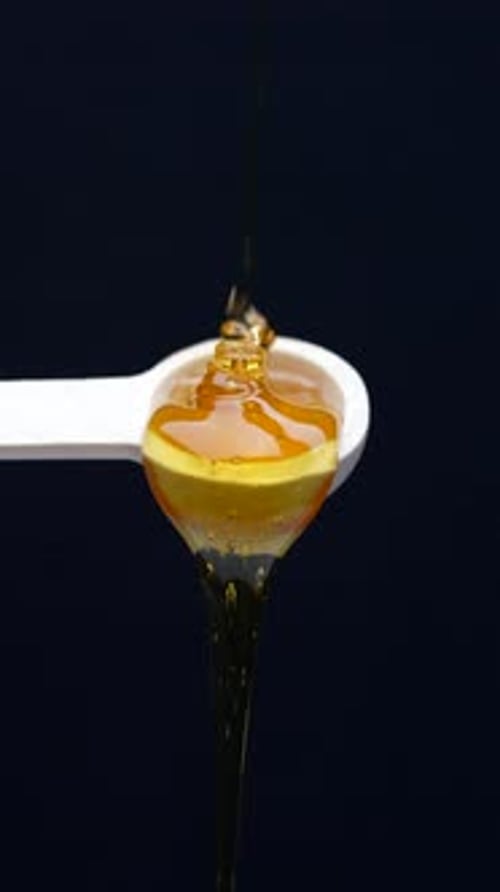 Honey Pouring onto Spoon