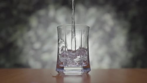 Water Pouring Into Glass Cup on Table