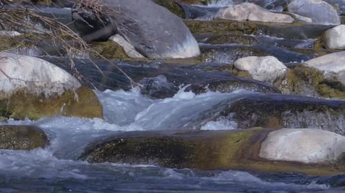 Small waterfalls of water flow over boulders on beautiful and serene river in Arizona.