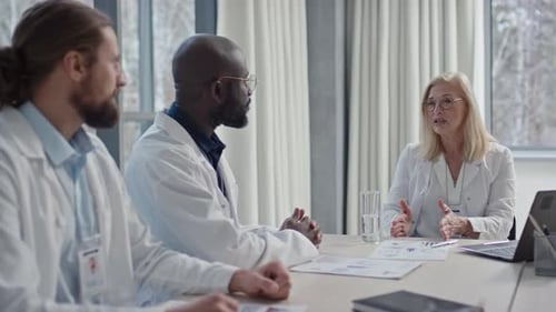 Medical Workers Brainstorming Ideas about Affairs of Clinic in Boardroom