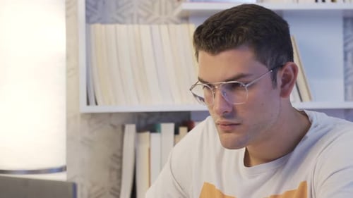 Young Adult Working on Laptop at Home Desk