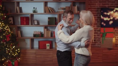 Senior Couple Dancing Together During Christmas Celebration