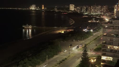 Time lapse shot of traffic on coastal road at night in Punta del Este City,Uruguay -. Aerial top dow