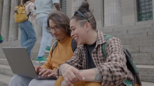 Student Using Laptop and Talking with Girlfriend on Stairs outside University