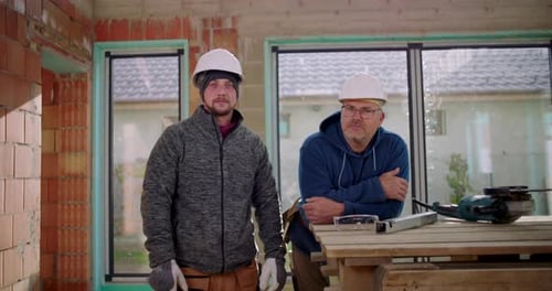 Construction Workers in Building Under Construction Look at Camera