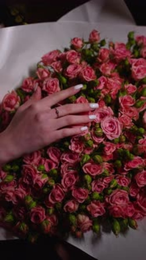 Elegant Hand Touching Bouquet of Pink Roses