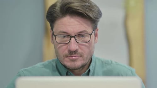Close Up of Middle Aged Man Typing on Laptop in Office