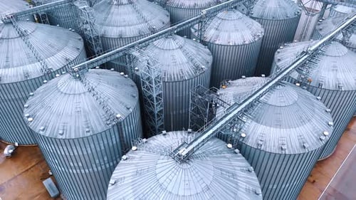 Riesige Metalltanks mit kegelförmigen Oberteilen. Getreidespeicheraufzüge für die Lagerung von Getreide in landwirtschaftlichen Betrieben
.