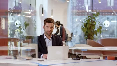 Businessman sitting in office using laptop at desk