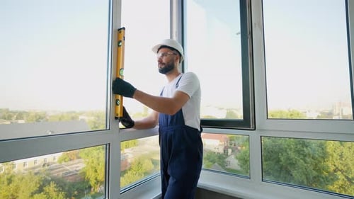 Construction Worker Ensuring Window Alignment with Spirit Level