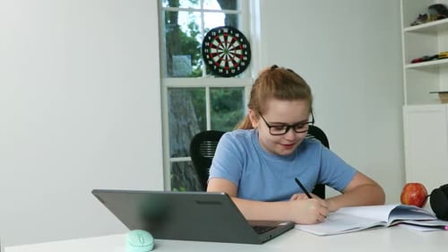 Girl Doing Homework at Desk with Laptop Indoors