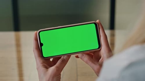 Woman Holds Smartphone With Green Screen Display