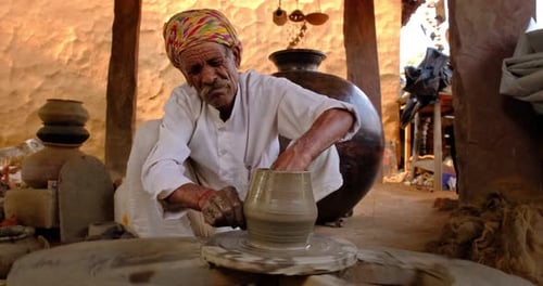 Potier indien au travail lançant le tour de potier et façonnant de la vaisselle en argile Rajasthan Inde