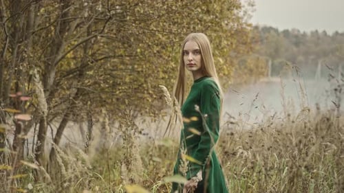 Model posing wearing green dress in autumn nature