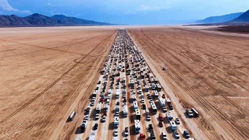 Multi-lane road crossing the desert is stuck with cars and campervans.