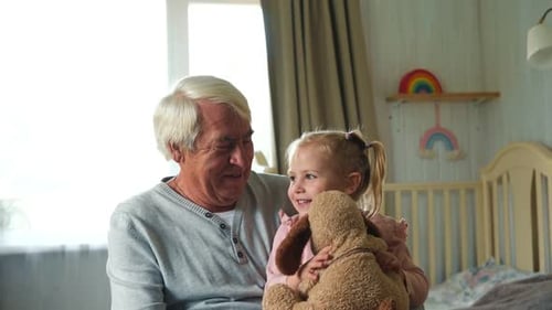 Grandfather and Granddaughter Play Together Indoors