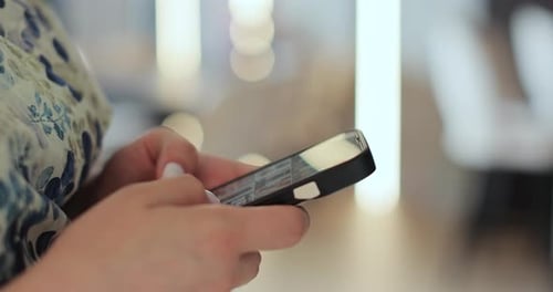 Woman's Hands Using Smartphone Device Indoors