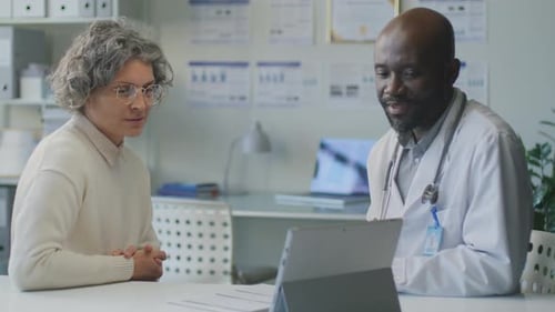 Mature Woman Meeting with Doctor Using Tablet