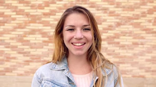 Smiling Woman Portrait in front of Brick Wall