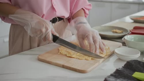 Person cuts omelet on cutting board at home