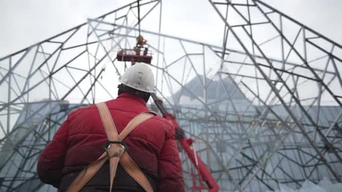 Worker in Helmet Observes Intricate Mesh Structure
