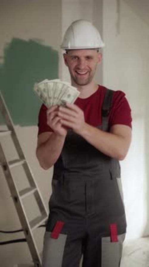 Construction Worker Counting Money During Home Renovation