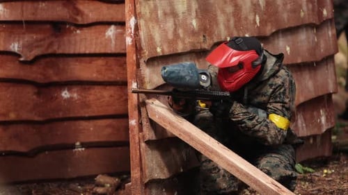 Paintball-Sportspieler trägt Schutzmaske und zielt auf Waffenschutz unter Angriff