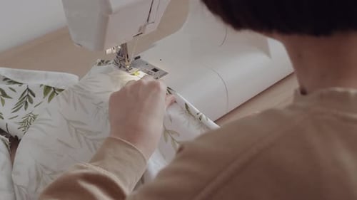 Female Tailor Sewing Fabric in Bright Workshop Space