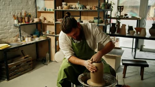 A man makes a clay pot on a ceramic wheel Ceramics Close-up A potter does pottery handicraft clay