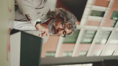 Mature businessman , working on tablet, sitting in an outdoor cafe