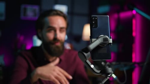 Focus on Cellphone on Selfie Stick Used By Influencer in Studio Recording Live