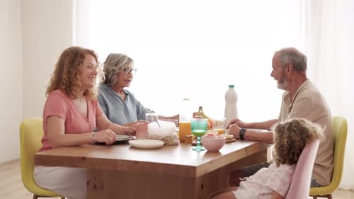 Family Gathered Around Dining Table Enjoying Meal Together