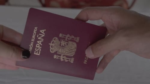 Hands exchanging Spanish EU passport close-up. Close view of a Spain European Document swap