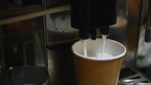 Coffee Machine Dispenses Milk and Espresso into Cup