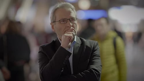 Pensive Adult with Gray Hair in Urban Setting