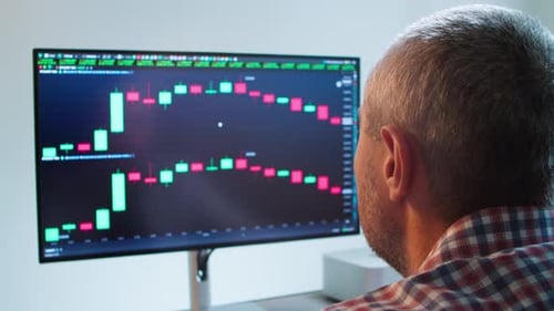 Businessman Looking at a Trending Market Chart on a Computer Monitor