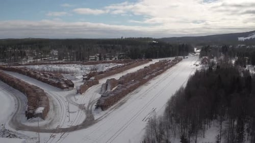 Cinematic aerial shot of a huge timber yard in the snow