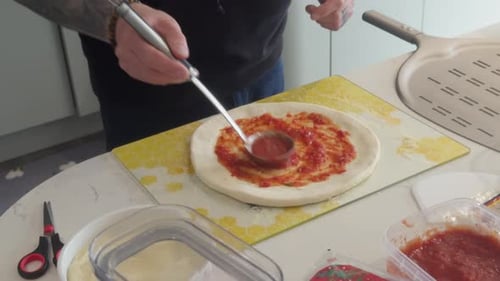 Pizza making at home with delicious homemade sauce.