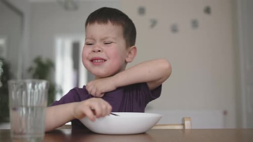 Child with Purple Shirt Sitting at Table