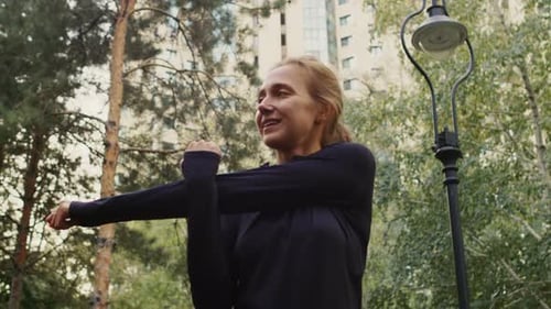 Caucasian Woman in the Park Outdoors Doing Stretching Exercise with Her Hands
